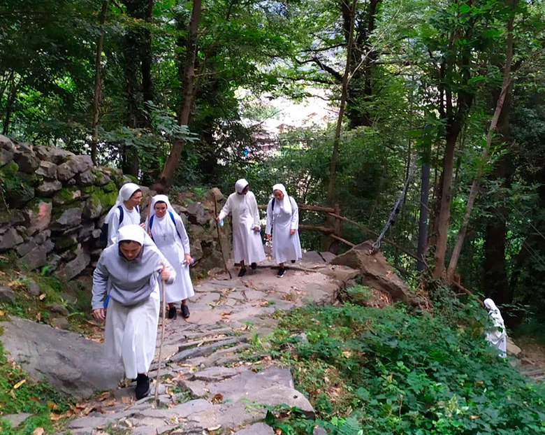 Grupo de cinco monjas caminan por el monte
